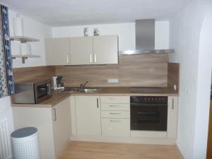 a small kitchen with white cabinets and a sink at Ferienwohnung Saskia in Deiningen