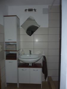 un bagno con lavandino e luce sopra di Ferienwohnung Saskia a Deiningen