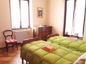 a bedroom with two beds and a dresser and windows at Como Country House in Cavallasca