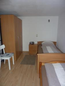 a bedroom with a bed and a dresser and a chair at Ferienwohnung Saskia in Deiningen