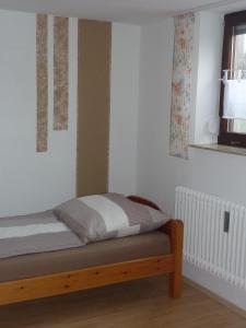 a small bed in a room with a window at Ferienwohnung Saskia in Deiningen