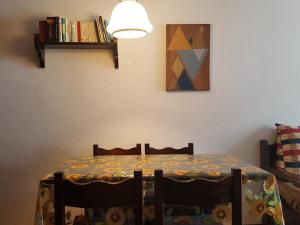 a table and chairs with a table and a lamp at Bardostudio in Bardonecchia