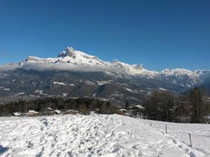 Rez de chaussée très calme vue Mont-Blanc في كومبلو: جبل مغطى بالثلج أمام جبل مغطى بالثلج