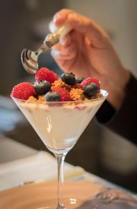 a person is preparing a dessert in a martini glass at B&B Het Postenhofje in Puiflijk