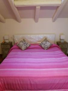 uma cama rosa com duas almofadas em cima em Billy house em Acireale