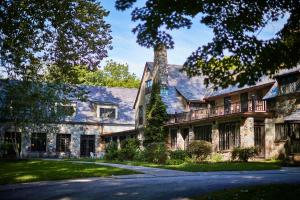 an old stone house with a gambrel roof at Troutbeck in Amenia