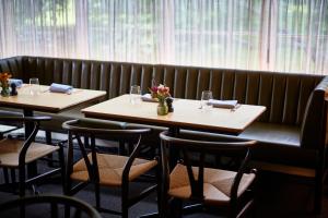 two tables in a restaurant with flowers on them at Troutbeck in Amenia