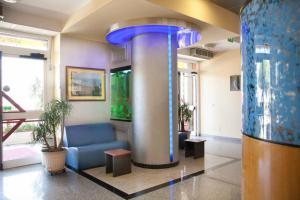 a lobby with a blue couch and a fish tank at Apparthotel Residence Riviera dei Cedri in Santa Maria del Cedro +114 photos