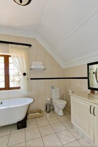 Un baño con bañera, inodoro y lavabo. en Eagle Wind Manor, en Hillcrest