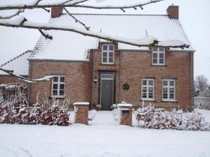 a brick house in the snow at B&B Het Postenhofje in Puiflijk