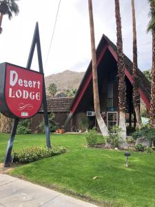 a sign in front of a house with a desert lodge at Desert Lodge in Palm Springs