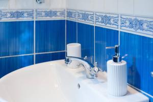 a bathroom with a sink and a blue tiled wall at Love weekend near Piazza Ognissanti in Florence +16 photos