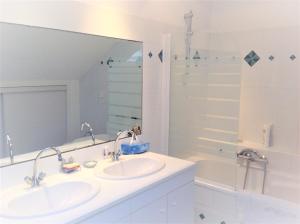 een witte badkamer met een wastafel en een douche bij Chambres Saint Donatien in Nantes