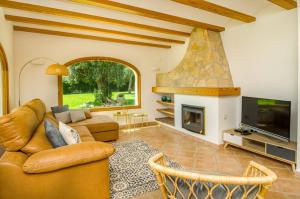 a living room with a couch and a fireplace at Villa Miramar, Luxury Villa Rental - Javea in Balcon del Mar