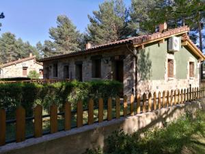 una casa con una valla delante de ella en Los Ranchales Vinuesa, en Vinuesa