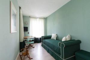 a living room with a green couch and a table at B&B a Ca' Minore Franciacorta in Passirano