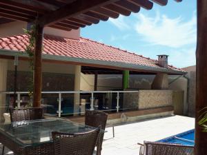 um pátio com mesa e cadeiras e uma piscina em Casa Temporada Daniel- Olímpia SP em Olímpia