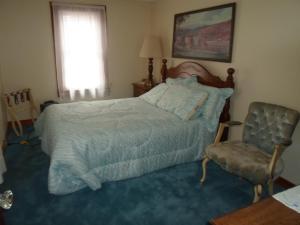 a bedroom with a bed and a chair and a window at Fishing Creek Lodge at Ricketts in Benton