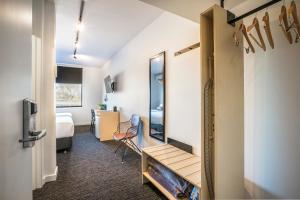ein kleines Zimmer mit einem Schlafzimmer mit einem Bett und einem Spiegel in der Unterkunft Nightcap at The Cheeky Squire in Frankston