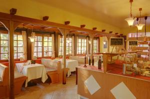 ein Restaurant mit Tischen, Stühlen und Fenstern in der Unterkunft Hotel Naheschlößchen in Bad Münster am Stein-Ebernburg