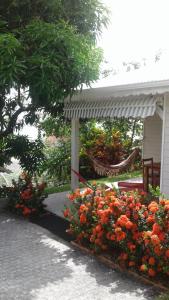 - une terrasse couverte avec un bouquet de fleurs devant une maison dans l'établissement Bungalow le manikou, à Le Robert