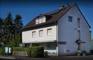 una grande casa bianca con tetto di gambero di Pension Waldau a Kassel