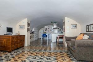 ein Wohnzimmer mit einem Sofa und einer Küche in der Unterkunft Casa Katy in Siena