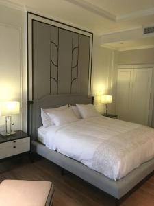 sypialnia z dużym białym łóżkiem z 2 lampami w obiekcie NirvaNAN House w mieście Nan