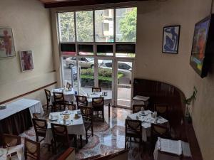 a dining room with tables and chairs and a window at Hotel del Principado in Mexico City