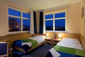 Un pat sau paturi într-o cameră la Jagelló Business Hotel