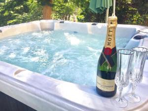 eine Flasche Wein und zwei Gläser im Whirlpool in der Unterkunft TAURO GOLF & BEACH VILLA in Mogán