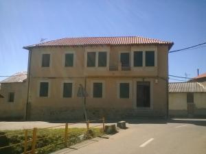 an old house with a fence in front of it at Casa Rural La Dama del Alba in Vega de Magaz