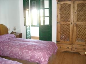 a bedroom with a bed and a wooden cabinet at Casa Rural La Dama del Alba in Vega de Magaz