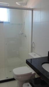 a bathroom with a toilet and a shower and a sink at Prainha Aconchegante apto de quarto e sala com vista para o mar in Arraial do Cabo