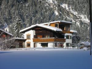 ein Gebäude mit Schnee vor einem Berg in der Unterkunft Ferienwohnungen Kerber in Bach
