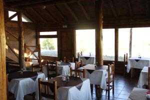 a restaurant with tables and chairs with white table cloth at Montaña Negra in Aluminé