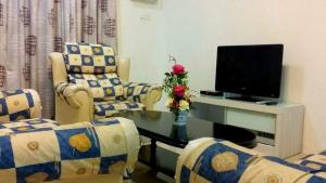 a living room with two chairs and a television at Golden Hill Double Storey Homestay at Night Market in Cameron Highlands