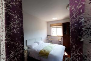 sypialnia z białym łóżkiem i oknem w obiekcie Alice Springs Homestay w mieście Tianfu