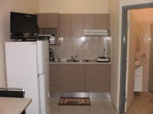 a kitchen with a white refrigerator and a sink at Molika Springs Motel in Moree