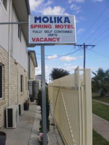 un letrero de la calle frente a una valla en Molika Springs Motel, en Moree
