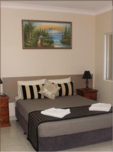 a bedroom with a bed with two towels on it at Molika Springs Motel in Moree