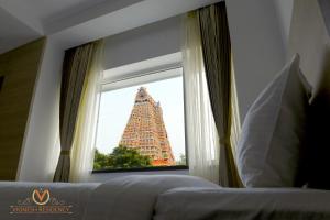 Postel nebo postele na pokoji v ubytování Vignesh Residency