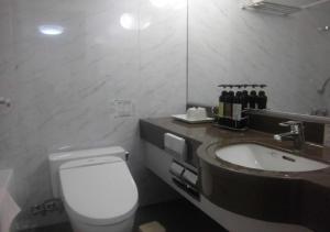 y baño con aseo blanco y lavamanos. en Terminal Hotel Matsuyama, en Matsuyama
