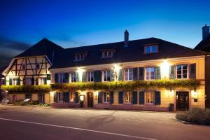 a large house with lights on the side of a street at Auberge Saint Laurent in Sierentz