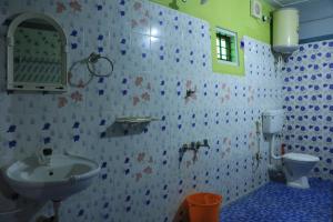 a bathroom with a sink and a toilet at Periyar Green Bed & Breakfast in Thekkady