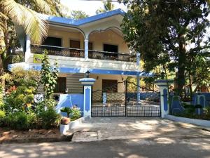 ein weißes Haus mit einem Zaun davor in der Unterkunft shirley's guest house in Majorda