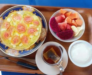 パダンバイにあるCelagi Innの卵、フルーツ、ソースの朝食付きのテーブル