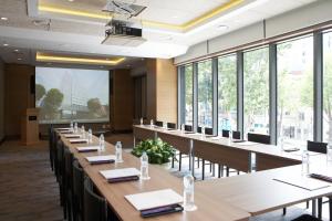 a row of tables in a room with large windows at Mayplace Hotel in Seoul