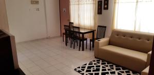 a living room with a couch and a table at Basic & Cozy Home in Bayan Lepas