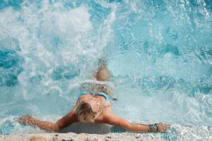 a young girl is laying in the water at Hotel La Floridiana in Capri